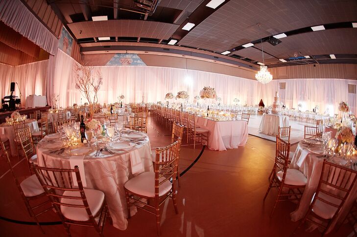 Maria and Chris had their reception at Holy Trinity Greek Orthodox Cathedral in Charlotte, North Carolina, because it was the church Maria grew up attending. The round tables around the outside of the room were topped with Manzetti trees with orchids. The entire hall was decorated with 22-foot draping.