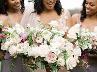 bride and bridesmaids stand side by side holding bouquets