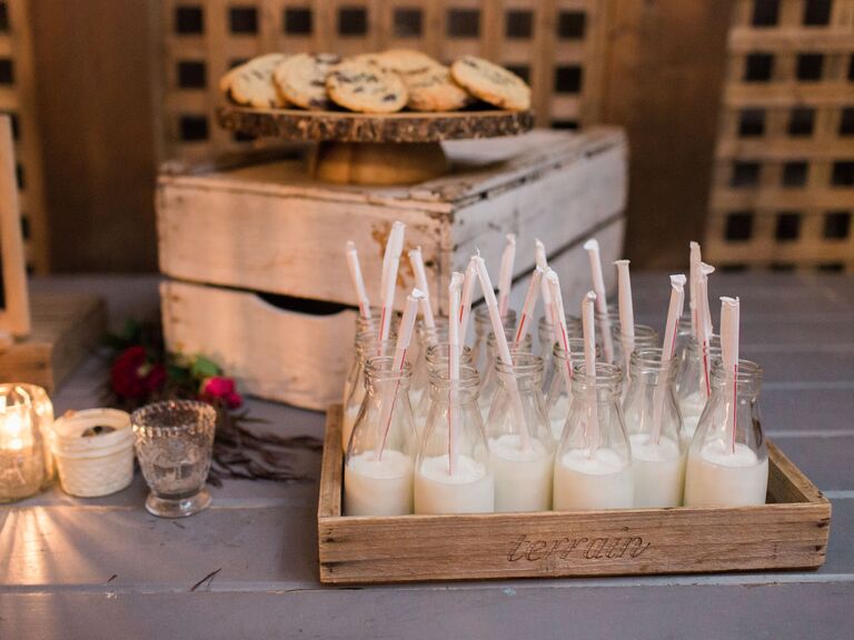 wedding dessert table with tray of chocolate chip cookies and milk in individual glass bottles with straws