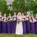 The bridesmaids wore floor-length royal purple silk chiffon dresses. They completed their look with a small blush rose in their hair and white hydrangea bouquets.