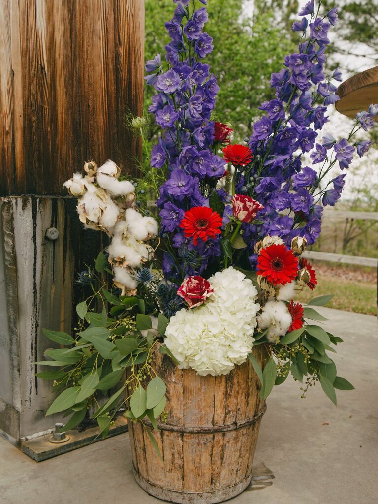 red, white and blue wedding flower arrangement in barrel
