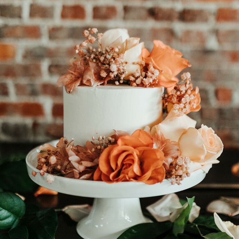 One-tier wedding cake with fresh orange flowers.