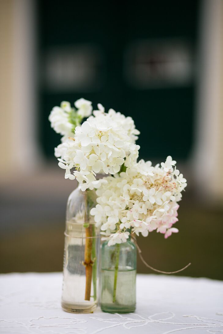 The couple celebrated their cocktail hour inside Laudholm Farm’s barn as guests enjoyed mini grilled-cheese sandwiches, french fry cones and lobster bisque shooters. Caitlin and Mike decorated the space with white linen-covered cocktail tables and simple white hydrangea centerpieces in bulb glass vases.