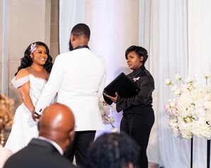 Bride in Off-the-Shoulder, Illusion Dress and Groom in White Tux at Altar With Officiant
