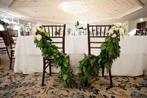 Green Garland Wrapped Around Couple Chairs