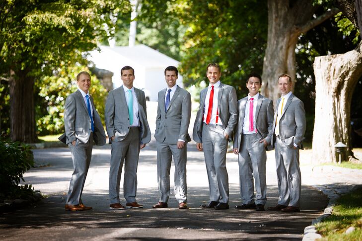 Groomsmen wore gray suits for the casual outdoor ceremony and kept with the vibrant, rainbow color format in bright, varied ties.