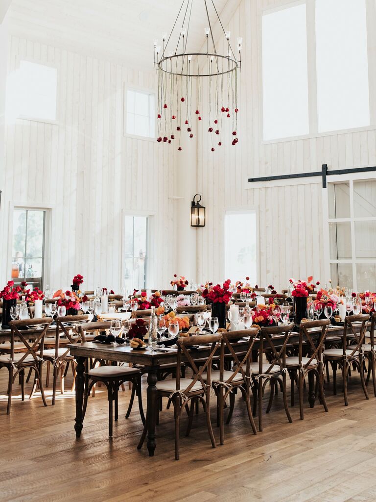 wedding barn venue with red long stem roses hanging upside down from round iron chandelier