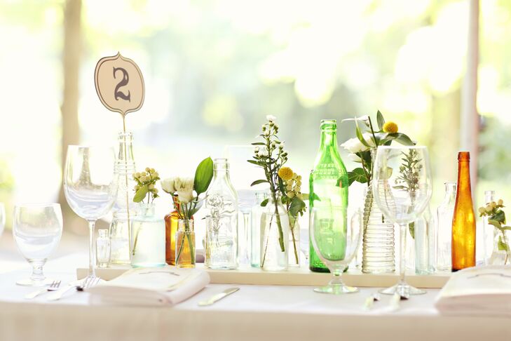 Aimee knew arranging 1,000 antique bottles on the reception tables would take too much time on the wedding day, so she affixed them to long strips of wood to make them easy to take on and off the tables.