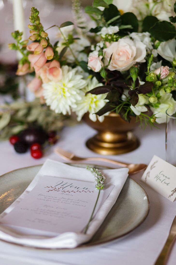 Garlands of lush greenery and abundant bouquets of dahlias, roses and foxgloves enlivened the elegant tablescape, while a fresh sprig of lavender at each place setting and stoneware dishes amplified the country charm.