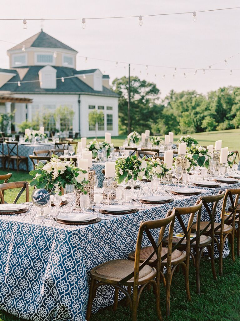 outdoor wedding reception table with navy blue and white patterned tablecloth