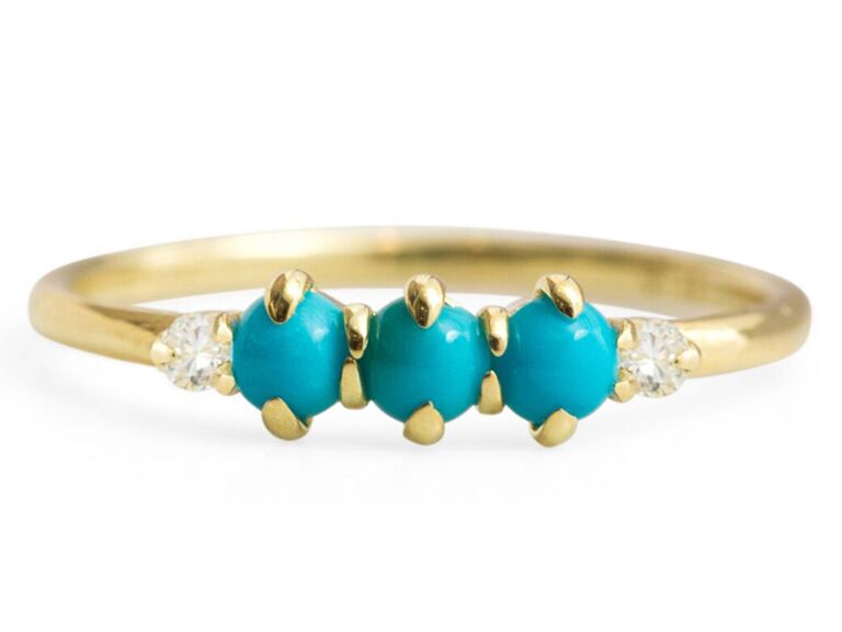 Three turquoise stones bordered by simple diamonds on gold band