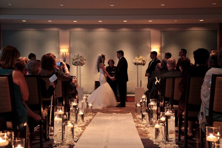 Joseph and Laura's ceremony was just as chic as their reception, with a white aisle runner flanked by high and low clear glass candle holders.