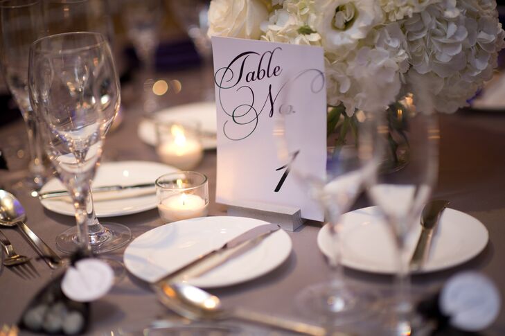 Laura and Joseph's table settings were classic and elegant, with white place settings, high and low white floral arrangements and black and white table numbers with elegant calligraphy.