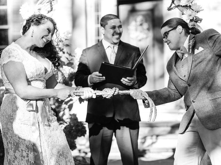 Couple tying eternity knot during wedding unity ceremony