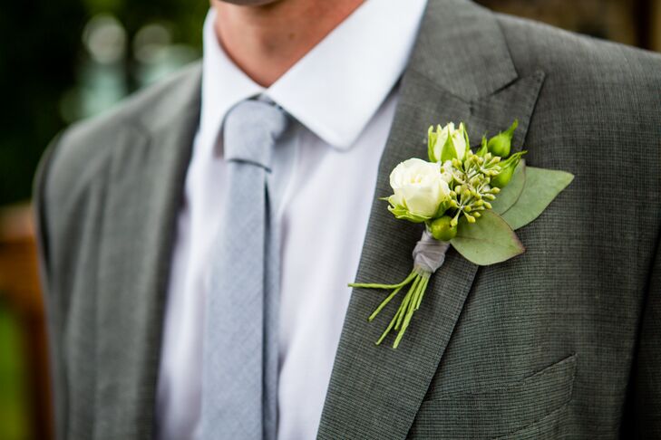 Jeff rocked a white rose, eucalyptus and leaf boutonniere, pinned to the lapel of his gray suit. The boutonniere matched Michelle's beautiful bouquet, filled with white garden roses and spray roses speckled with peach  blooms.