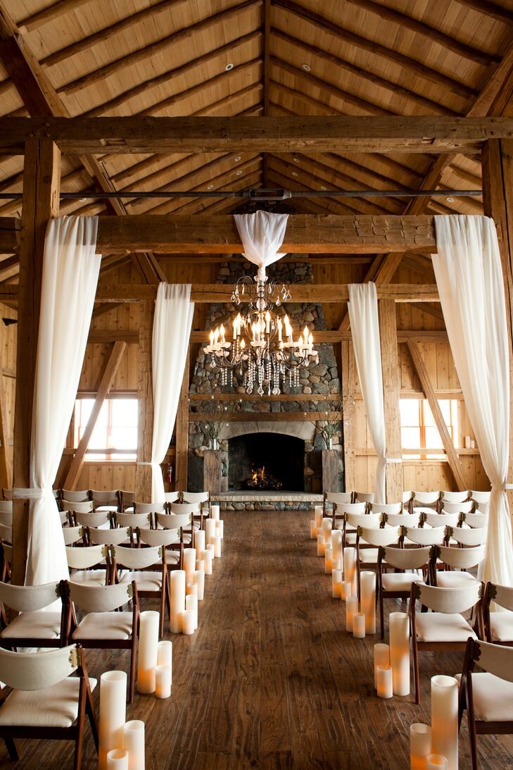 Panels of sheer, cream-colored fabric and elegant chandeliers were draped from the exposed wooden beams at Devil's Thumb Ranch to give the rustic space an elegant, romantic touch.