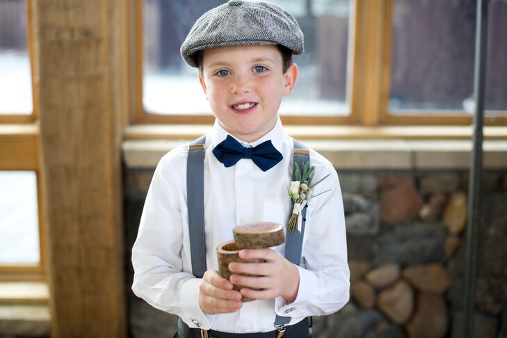 For a newsboy-inspired look, the ring bearer wore a classic gray flat cap, gray suspender s and a navy diamond-shaped bow tie.