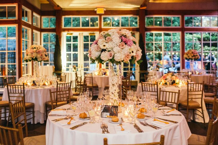 Michelle and Thorsten centerpieces consisted of white hydrangeas, quicksand roses,  touches of black-eyed gerbera daisies and cafe au lait dahlias. They were displayed in tall clear vases.