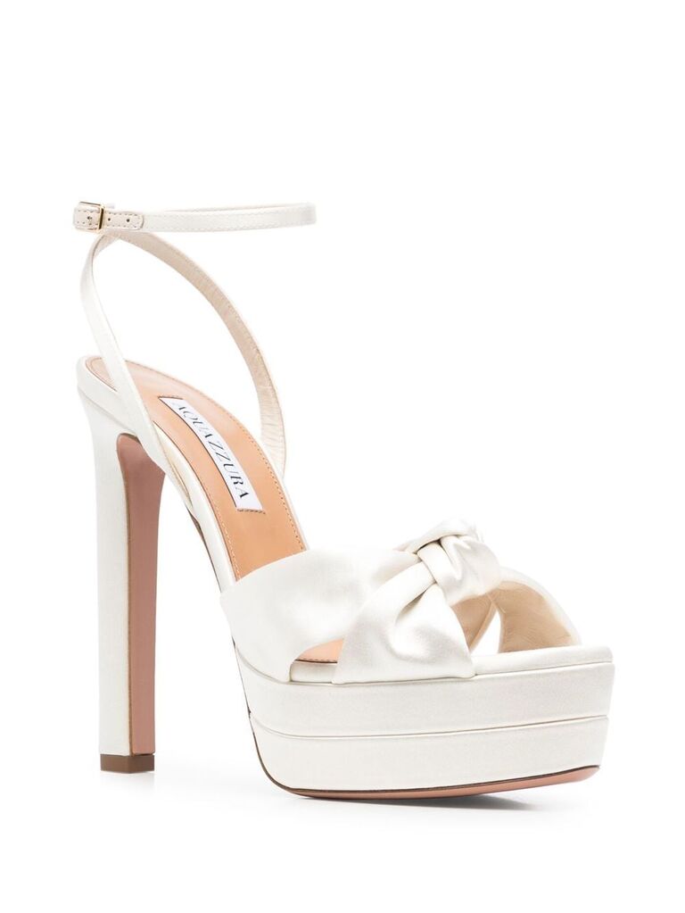 Tall pumps with an open toe and a bow embellishment. 