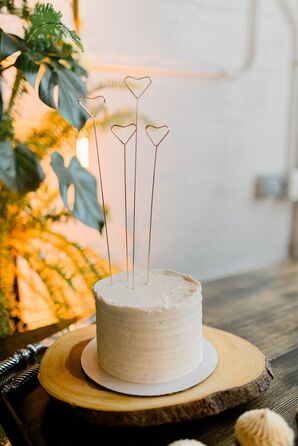 Single-Tier White Wedding Cake With Simple Heart Toppers on Wood Charger