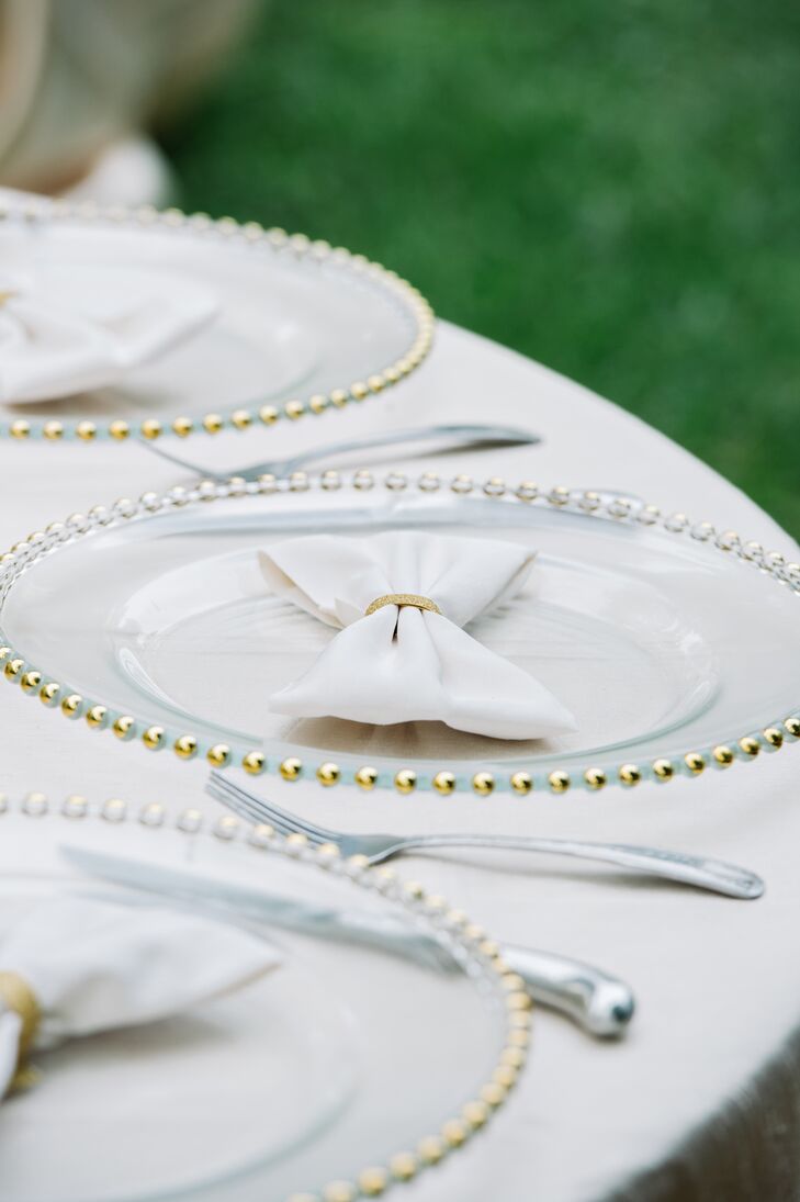 Gold beaded glass chargers were paired with bowtie-shaped ivory napkins tied off with a gold ribbon.