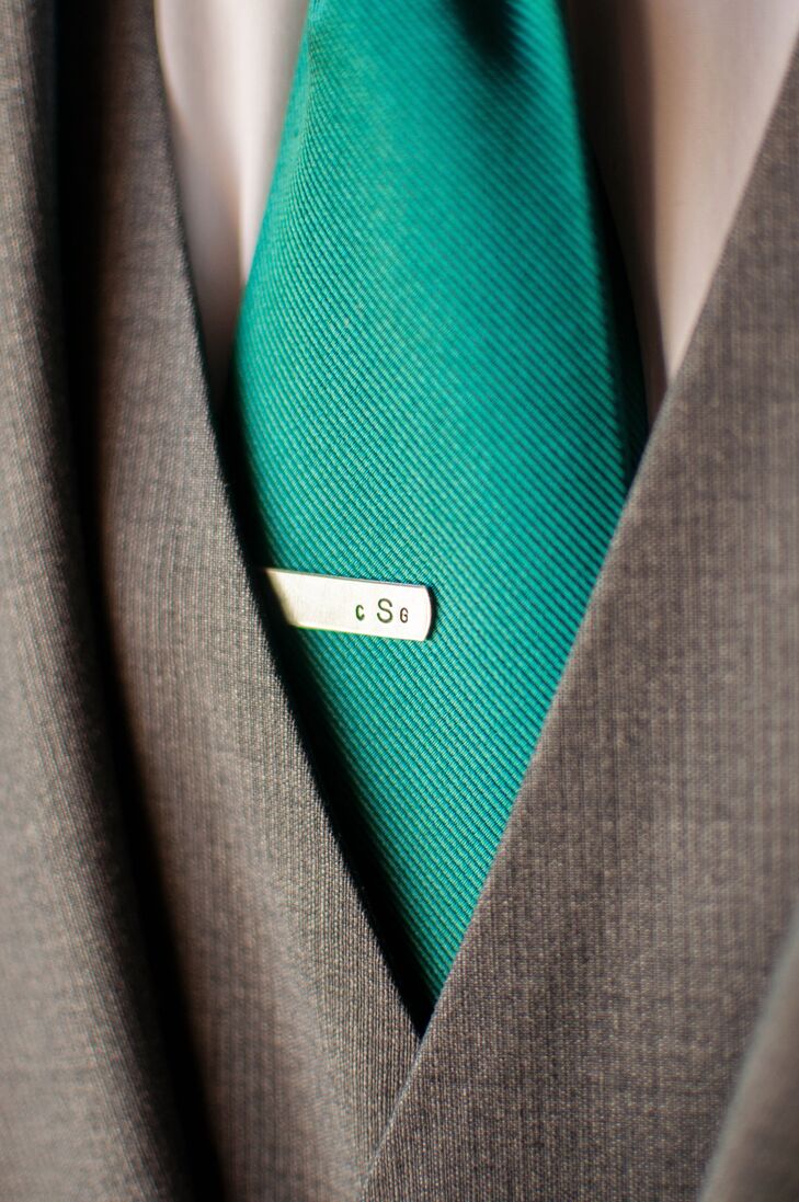 The groom accessorized his teal tie with an elegant monogrammed tie clip. While the groom wore a traditional jacket, his groomsmen stuck to shirts and suspenders.