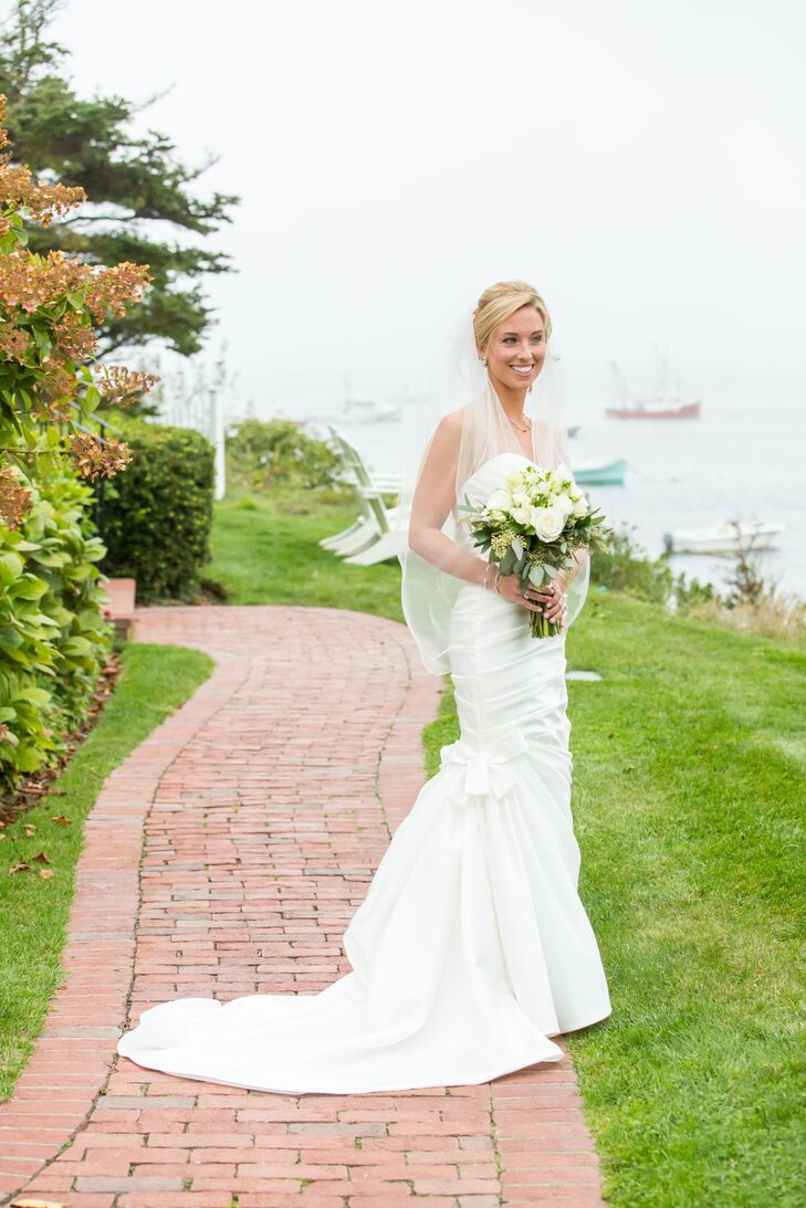 Classic elegance guided Alexandria's wedding dress decisions. She selected a strapless satin gown in a mermaid silhouette with a draped bodice, sweetheart neckline and bow-embellished skirt.