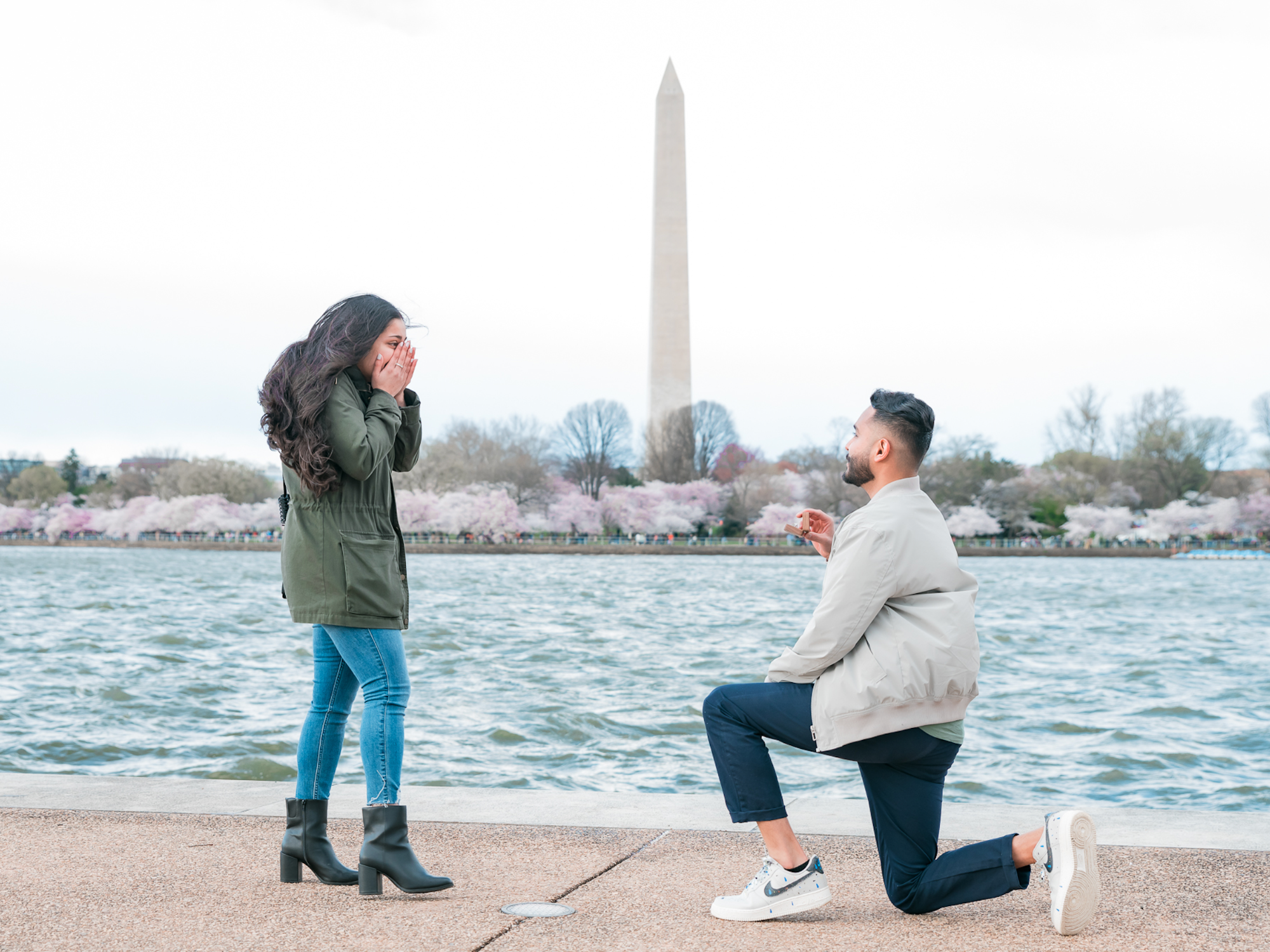 Man proposing to woman in front of water and washington monument in Washington DC