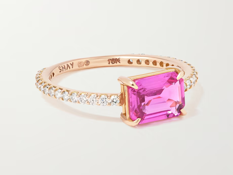 A pink rectangular sapphire in a gold band with small diamonds.