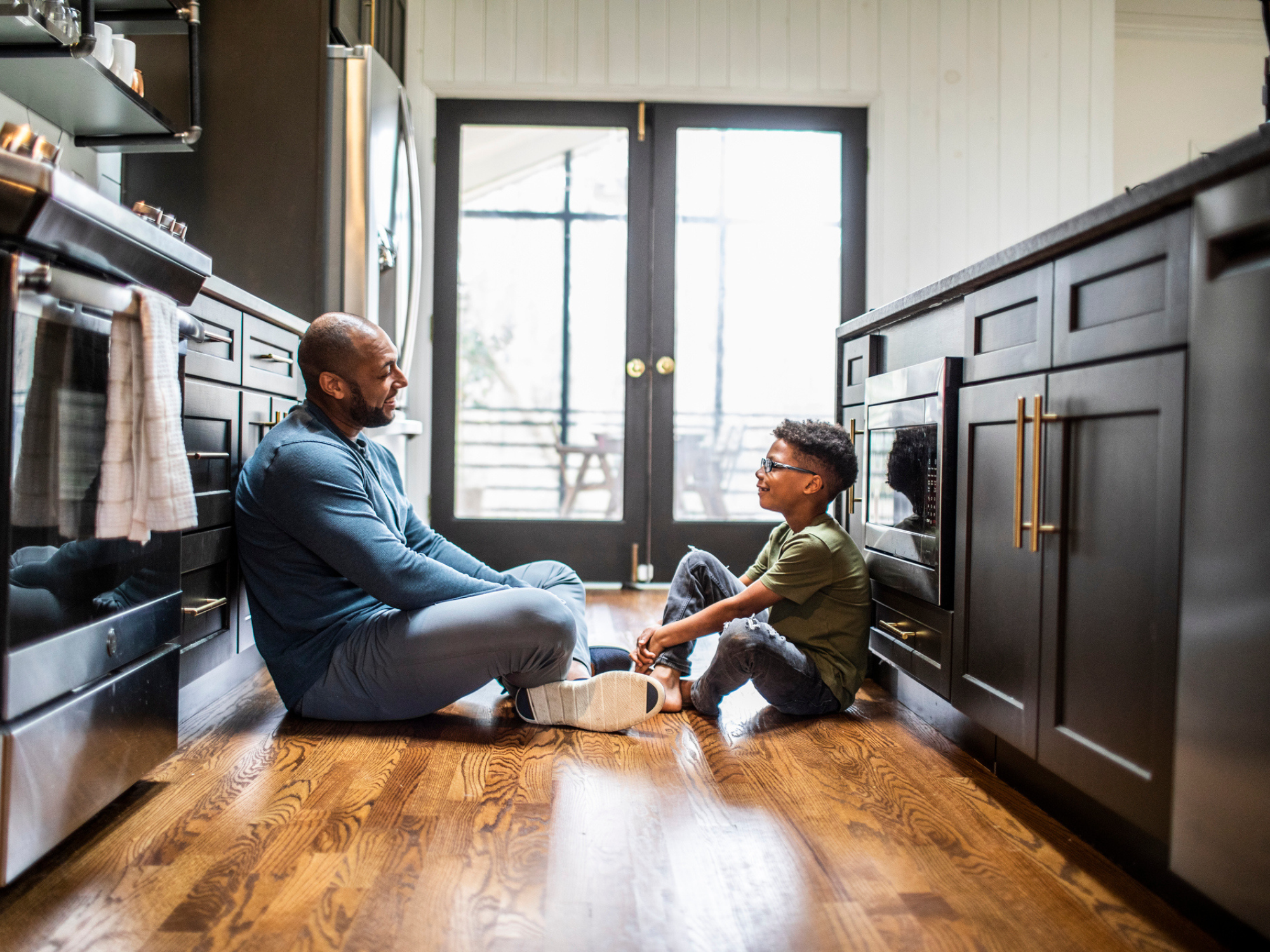 Dad and son talking on the kitchen floor