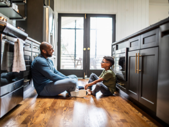 Dad and son talking on the kitchen floor