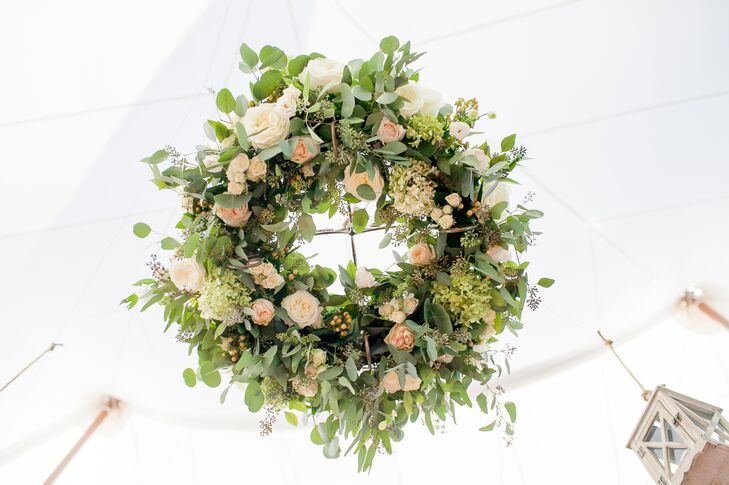 Dragonfly Events truly outdid themselves when it came to the reception decor, creating lush wreaths of eucalyptus, garden roses, hypericum berries and hydrangeas to hang from the ceiling of the open-air tent at Rebecca's parents' home in New Canaan, Connecticut. Paired with dozens of lanterns, the suspended arrangements injected the decor with an element of romance and whimsy.