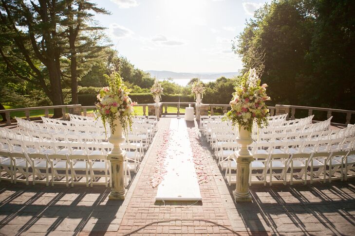 The ceremony took place outside of the venue, overlooking the Hudson River. The ceremony decorations were romantic; there was a white aisle runner with pink rose petals strewn down it and large floral arrangements at the beginning and end of the aisle.