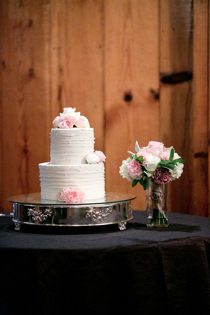 The two-tiered ivory wedding cake topped with pink and white flowers was positioned on an elegant silver stand at the reception. "Dessert was my favorite part, and we did a small traditional cake with strawberry filling," Raquel says. "We also did a s'mores bar, where guests could roast their own marshmallows, and also a cheesecake bar, since I love cheesecake."
