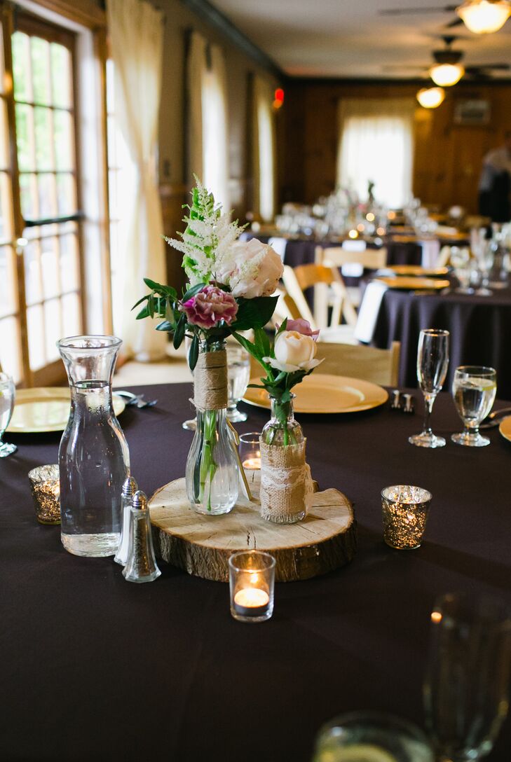 The reception took place on the middle floor inside the lodge, where dining tables were decorated in plum-colored linens and set with gold plates. The middle of the table was decorated with carnation, peony, rose and veronica flowers arranged inside glass vases, which were wrapped with burlap and lace. The centerpieces were positioned on top of wooden slabs and surrounded by candle votives.