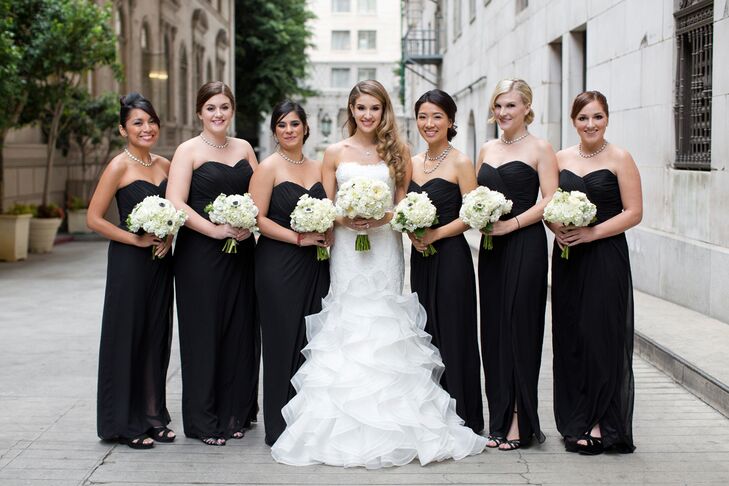 The bride stood with her bridesmaids, who were wearing long floor-length black strapless dresses with sweetheart cuts, purchased from The Dessy Group. The bridal party all held their ivory rose and hydrangea bouquets made by Lavenders Flowers.