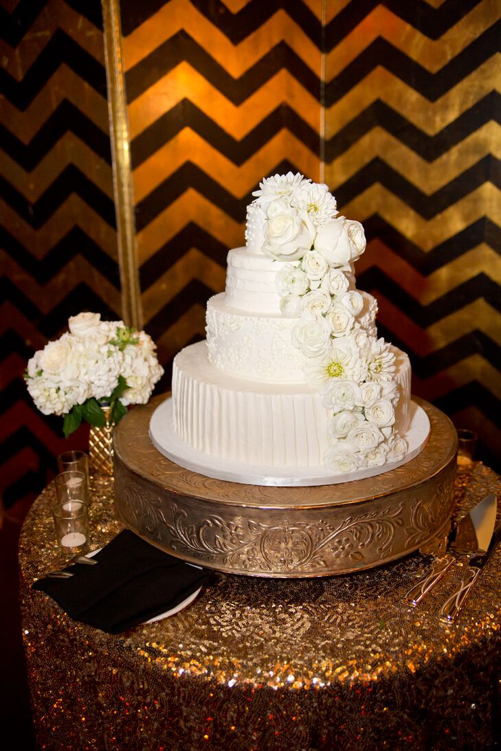 The four-tiered ivory wedding cake was designed by Joanie & Leigh's Cakes, accented with ivory roses and daisies.