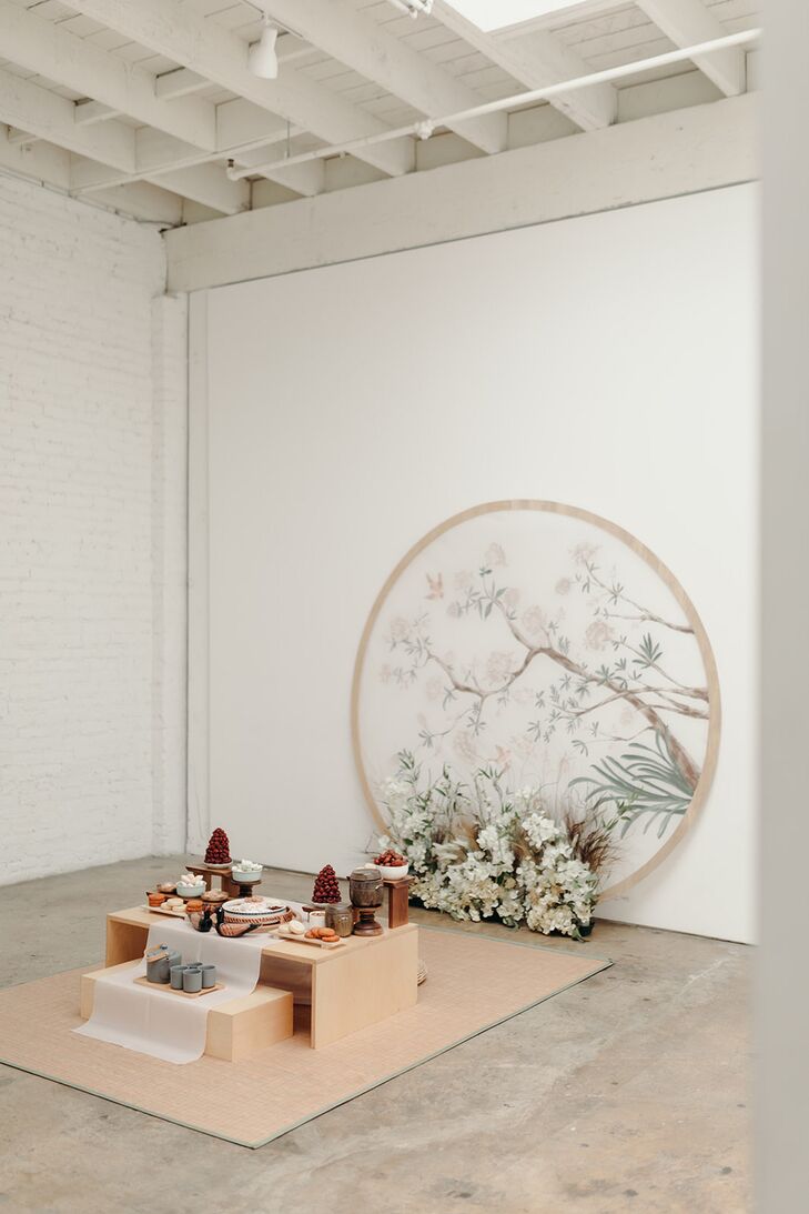 Pastel Paebaek Tea Ceremony Setup With Low Table, Hand-Painted Backdrop and Flowers, Korean Wedding