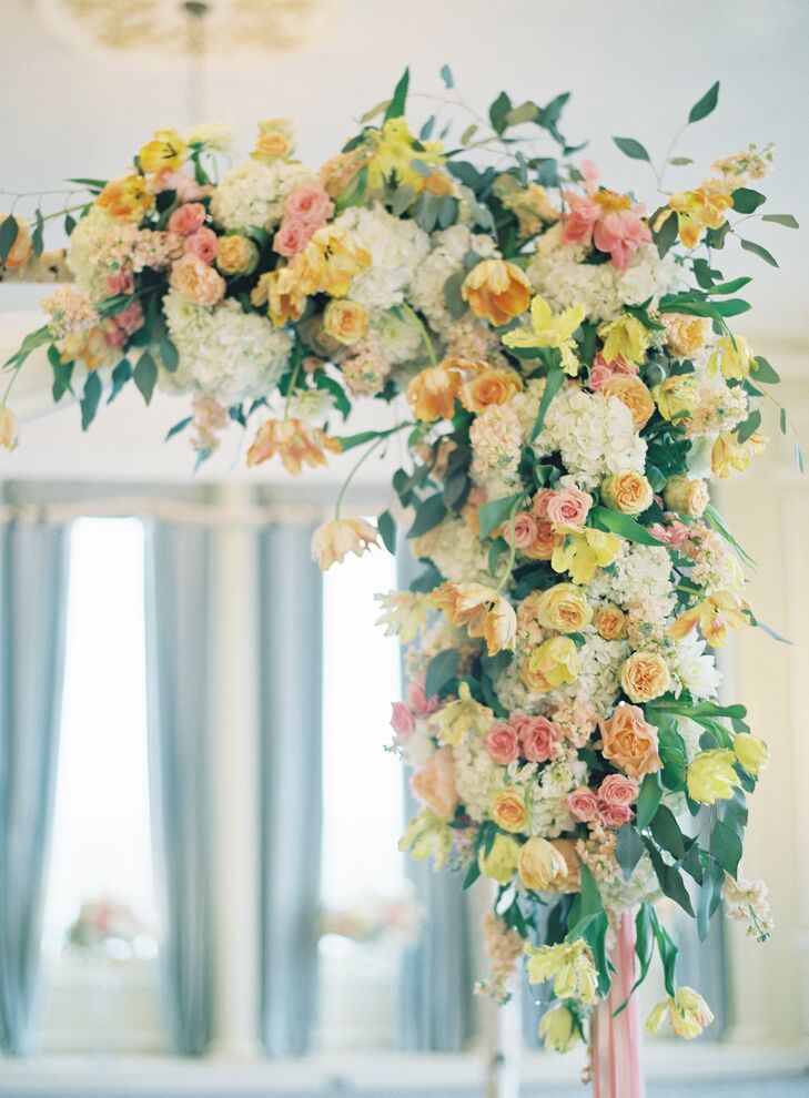 Simplicity was key when it came to the ceremony decor, with Alyse and Dimitry adding a few understated bundles of peach-colored blooms to alternating rows lining the aisle. But for their huppah, the couple decided to go all out, making the traditional detail the focal point of the room. The Special Event Florist used tulips, hydrangeas, stock, roses and lilies in a cheerful, spring-inspired color palette to create a striking garland that cascaded down the birch structure, infusing the ballroom with energy and life.