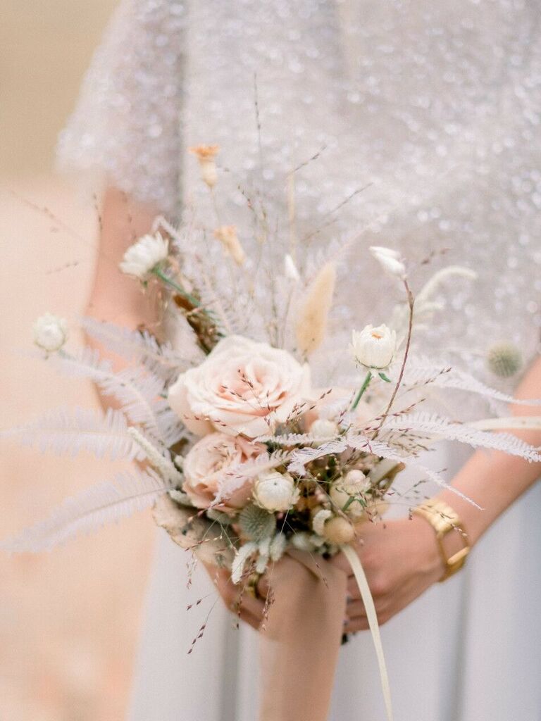 A bride holds this pale pink wildflower bouquet.