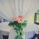White draping at the reception was tied with a green garland accented with pink roses.