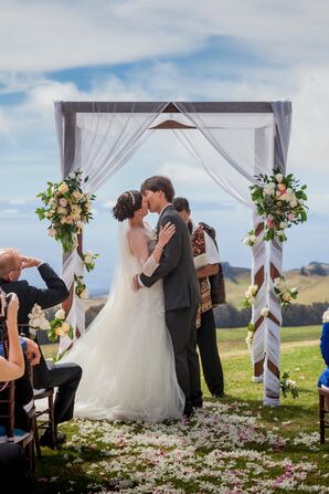 First Kiss Underneath Elegant Wedding Arch