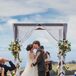 First Kiss Underneath Elegant Wedding Arch