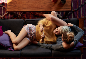two women cuddling on couch