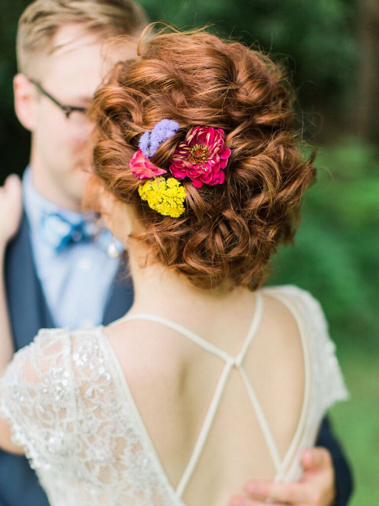 wedding hair flowers colorful florals in low bun