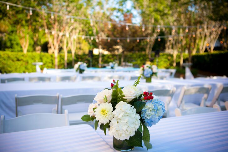 Centerpieces filled with a fresh mix of blue and white hydrangeas accented by red hypericum berries brought a light preppy touch to the reception tabletops.