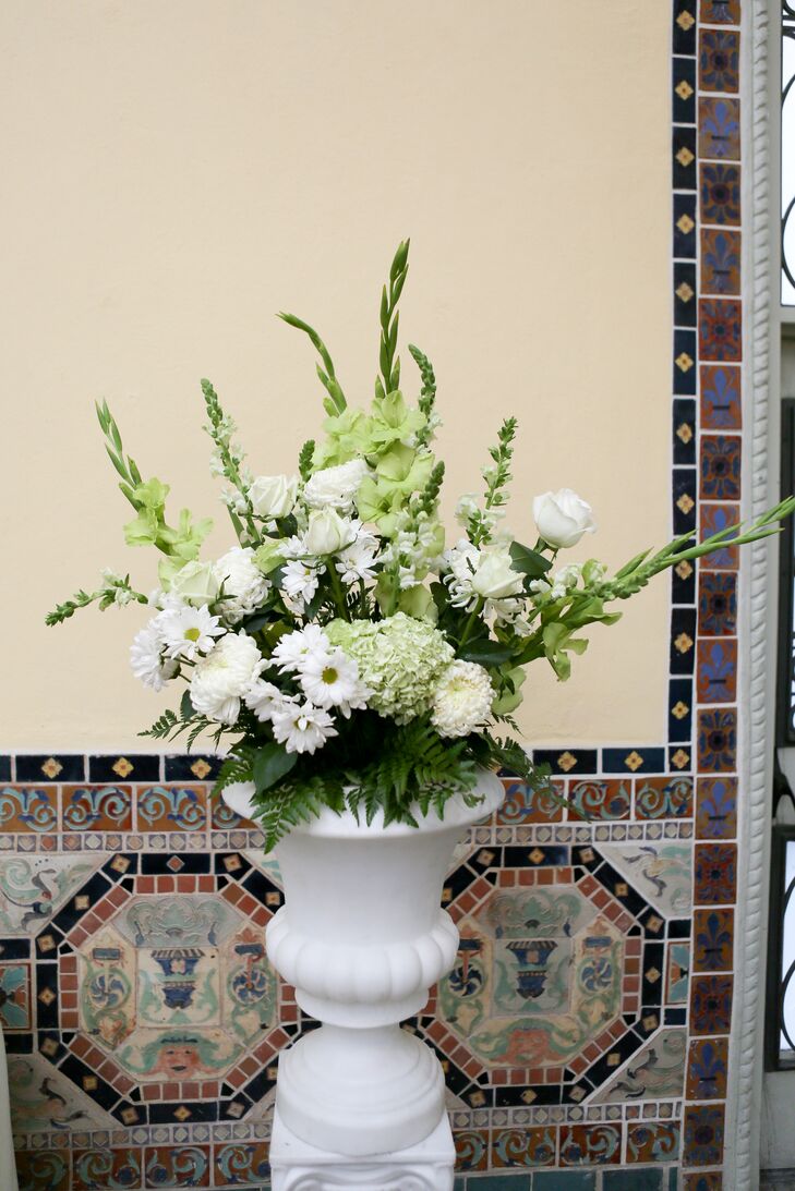 Large floral arrangements in white vases outside the venue had a mix of white and green daisies, hydrangeas, roses and lilies.