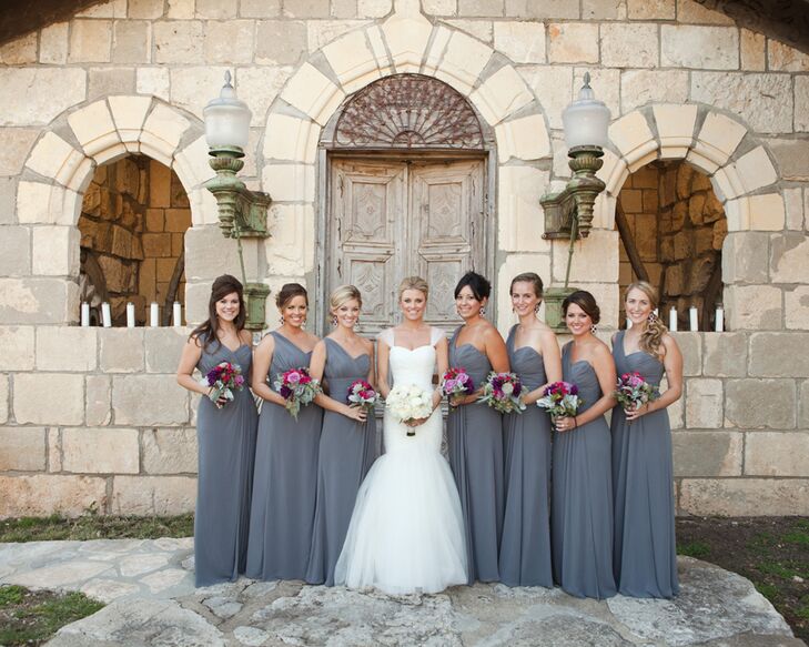 The bridesmaids wore soft slate one shoulder floor length chiffon gowns with plum-colored drop earrings from the bride to complete the elegant look.