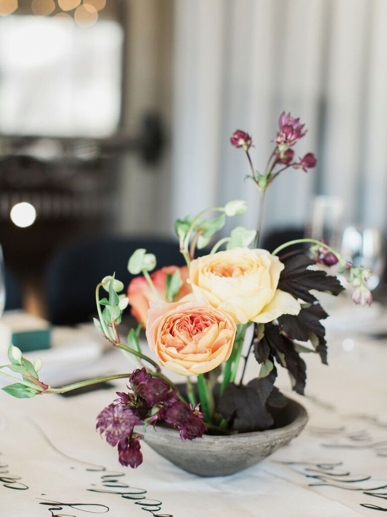 ikebana-style small wedding centerpiece with yellow roses and dark purple foliage