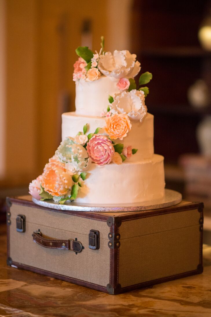 The couple served miniature cheesecakes as well as a traditional wedding cake for dessert. The three-tiered buttercream frosted confection included red velvet, chocolate and vanilla cake with Italian rum or hazelnut cream filling between each layer. Lora personally added gum paste flowers colored with peach, pink and green edible dusting powder, she says.